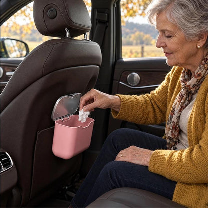 Poubelle de voiture rigide de couleur​ rose, à l'arrière du siège passager.